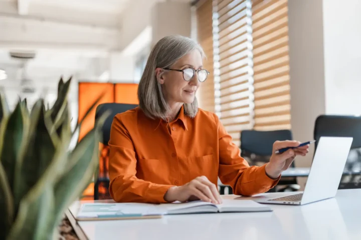 Woman working at a laptop at a bright desk