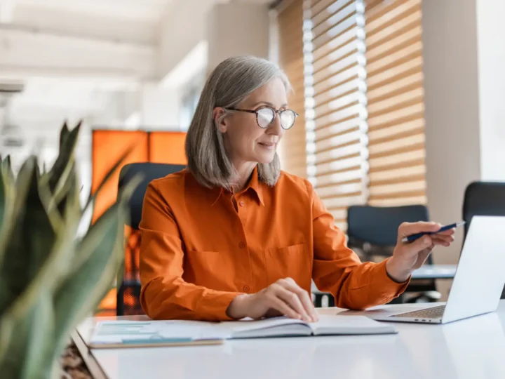 Woman working at a laptop at a bright desk