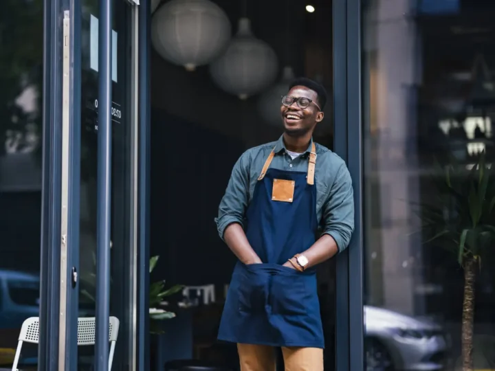 Man in an apron standing in his workshop doorway
