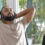 Man sitting back with eyes closed and headphones on