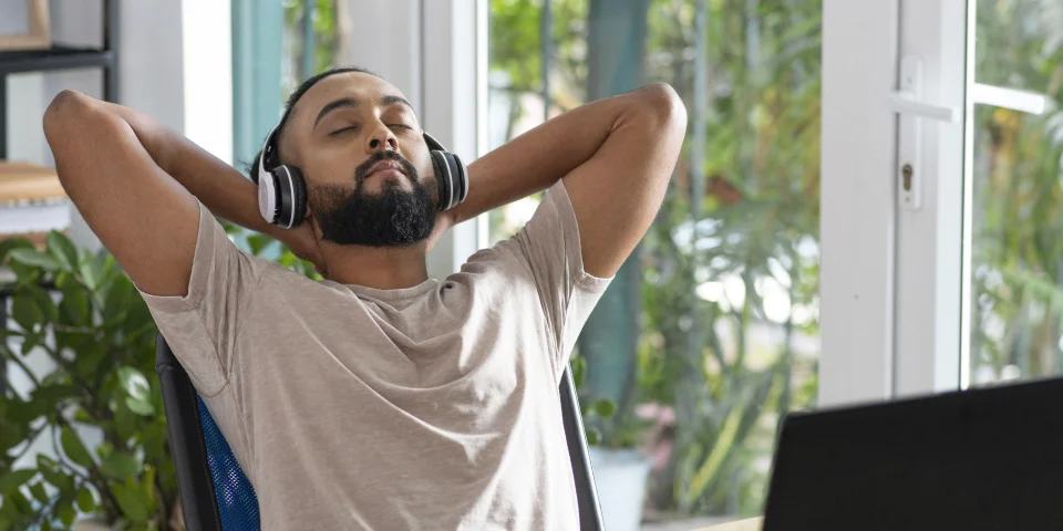 Man sitting back with eyes closed and headphones on